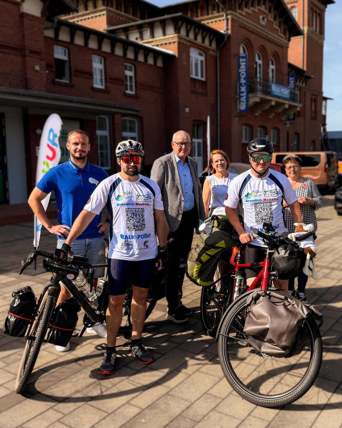 Start der Spendenradtour am historischen Bahnhof Eilenburg: zwei Radfahrer mit Talk-Point und Partnern vor der Tour für Wolfsträne e.V.